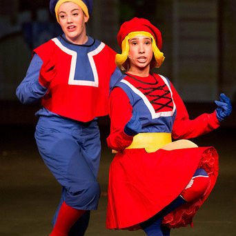 Theater students singing on stage in costume