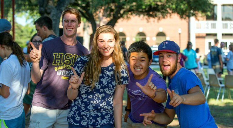 Students giving the HSU sign in a group photo