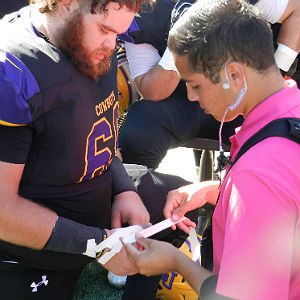 Athletic Training student puts bandage on football players hand