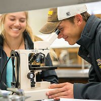 Biology Program student looking through microscope