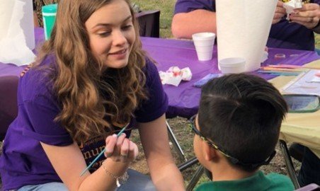 CSD student painting a kid's face at an HSU event.