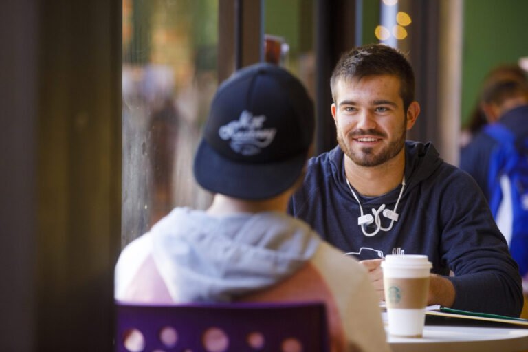 Photo of two Hardin-Simmons students chatting in a break room.