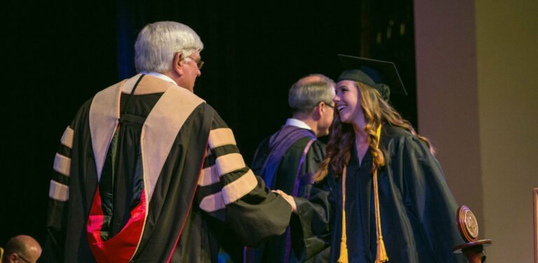 HSU student shaking professor's hand at graduation