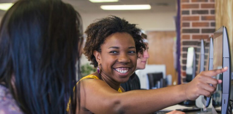 HSU student pointing to computer screen and talking to her classmate