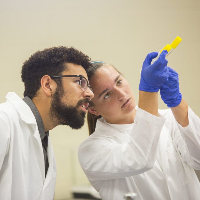 Student and professor examining test tube.