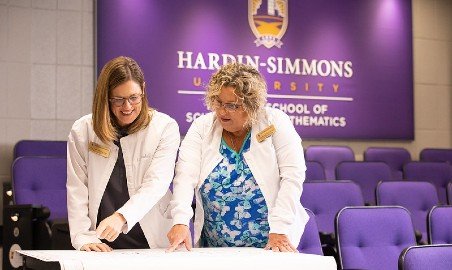 Nursing professors study a diagram.