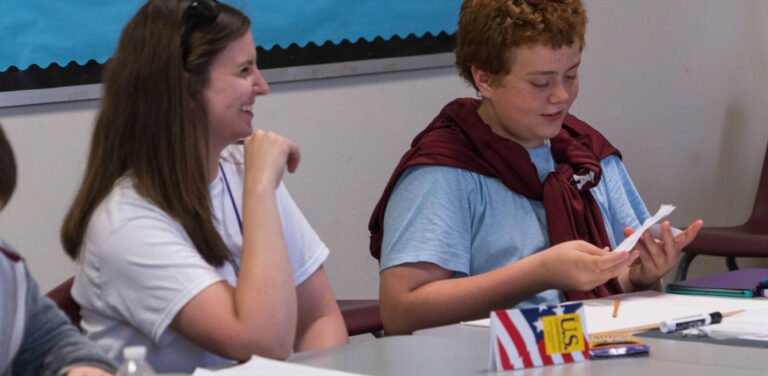 HSU students in class sharing notes and smiling