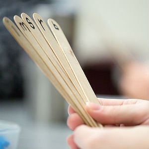 special education student holding popscicle sticks labeled with letters