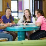 HSU students sitting at a round table talking, smiling, and laughing