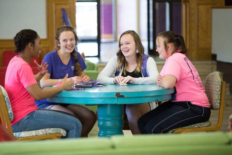 HSU students sitting at a round table talking, smiling, and laughing