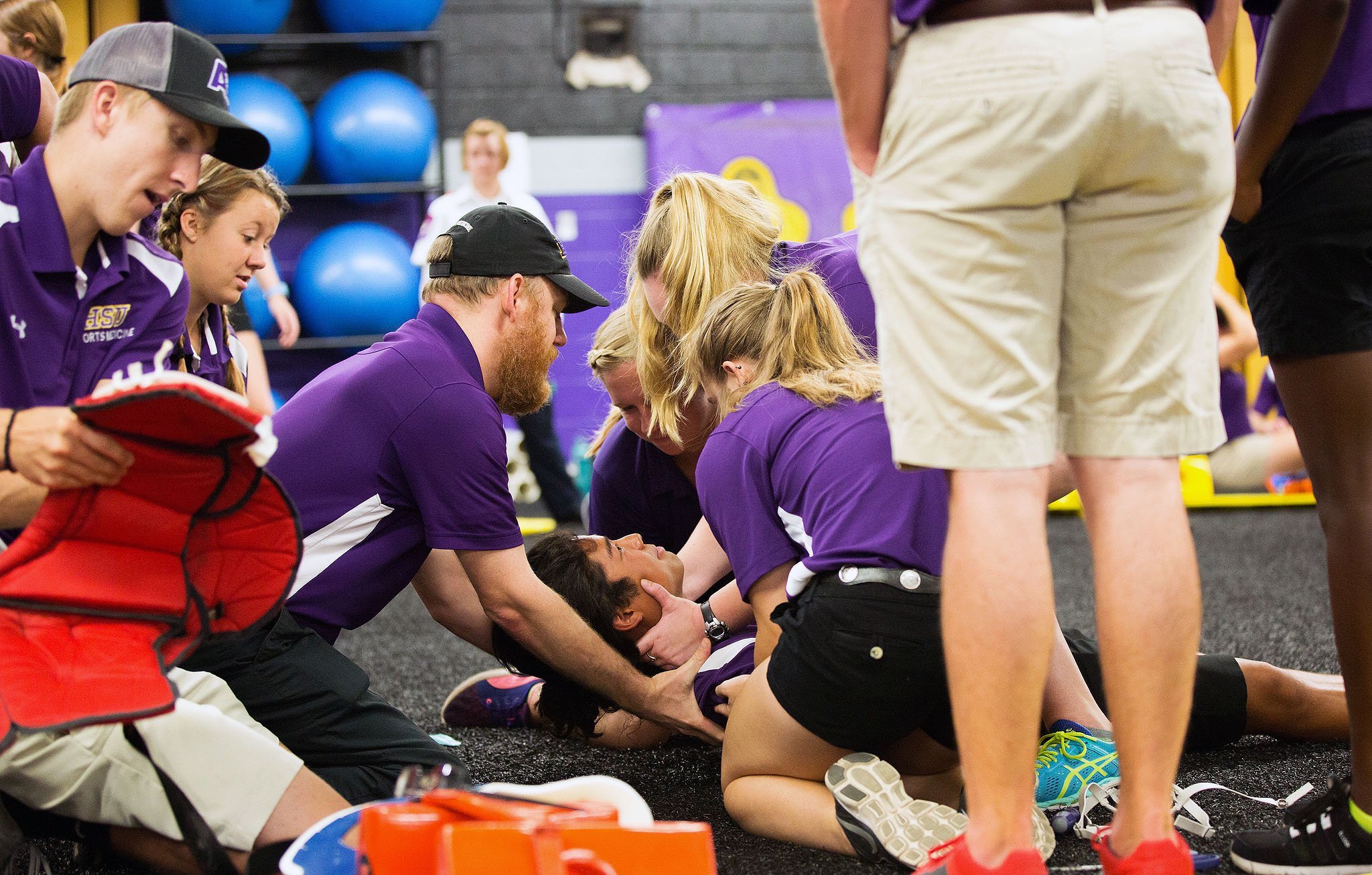 Athletic training students surrounding a student during a mock injury