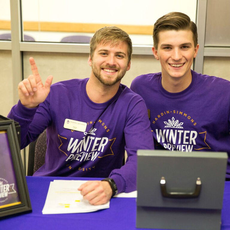 HSU students wearing Winter Preview t-shirts giving the HSU school sign