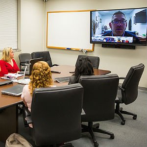 MSIS Professor conducting lecture via Skype to room of students