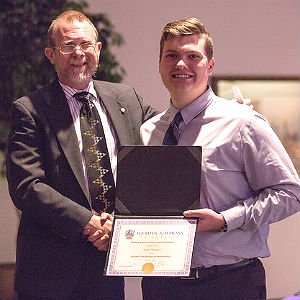 Professor shakes hands and presents student with a certificate