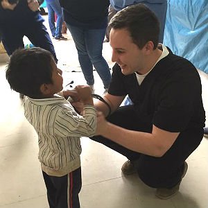 HSU Physician Assistant student lets little boy hold the stethoscope