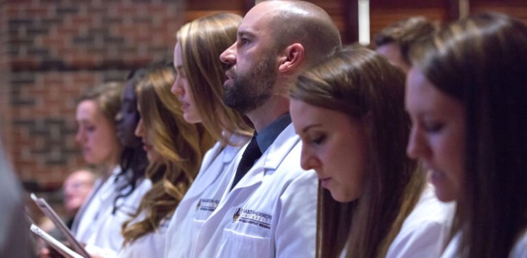 HSU Physician Assistant students dressed in white lab coats listening to a lecture