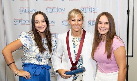 A nursing student poses with her daughters.