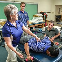 Physical Therapy professor demonstrating process with student volunteer
