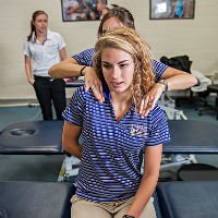 HSU student pointing to pain in back and other student massaging the pain point
