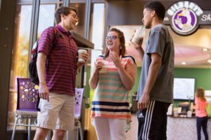 Photo of students at Gilbert's Coffee Shop in front of Richardson Library at HSU.