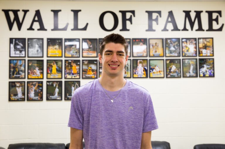 Caleb Spoon-Mathematics Major standing in front of the Wall of Fame