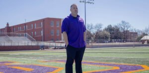 Coach Jesse Burleson standing in the football field