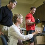 HSU student lifting weight while professor uses pc device to measure performance