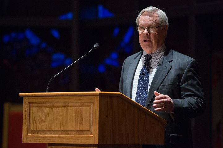 Dr. George Knight standing behind the podium giving a lecture