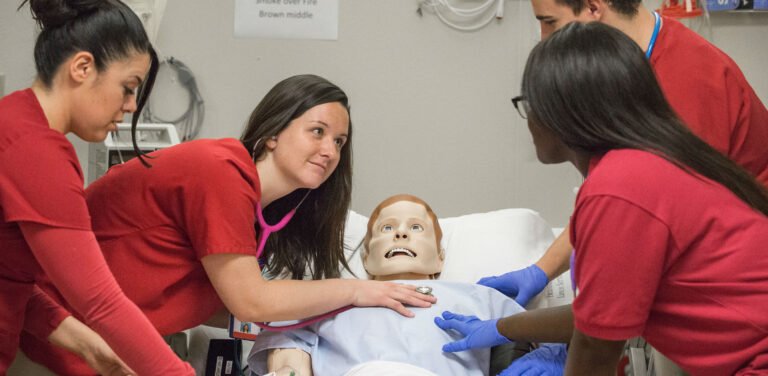 HSU nursing students examing dummy with a stethoscope