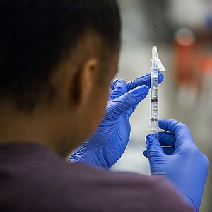 HSU nursing student holding and observing saline in syringe