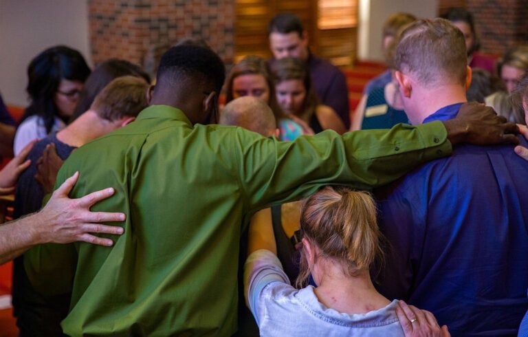 group of HSU students bowing thier heads and praying together