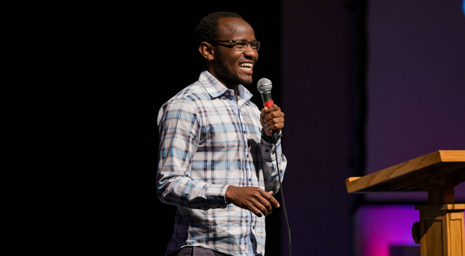 HSU speaker holding a microphone gives a lecture in the auditorium