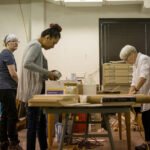 HSU Art professor and student creating art at a work table in an art studio