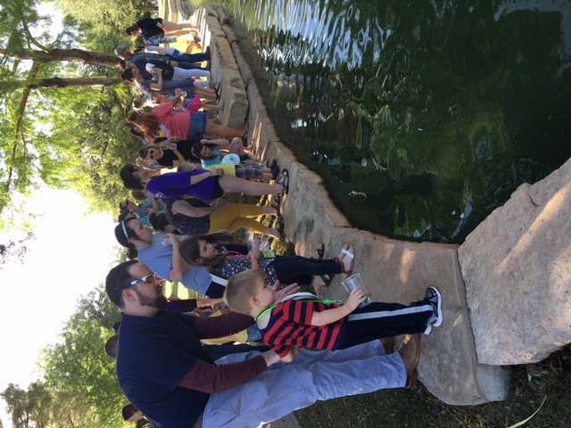 HSU Exploration Station students and parents stand on the edge of a creek
