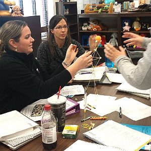 HSU Human Services professionals building tower of sticks together in team activity