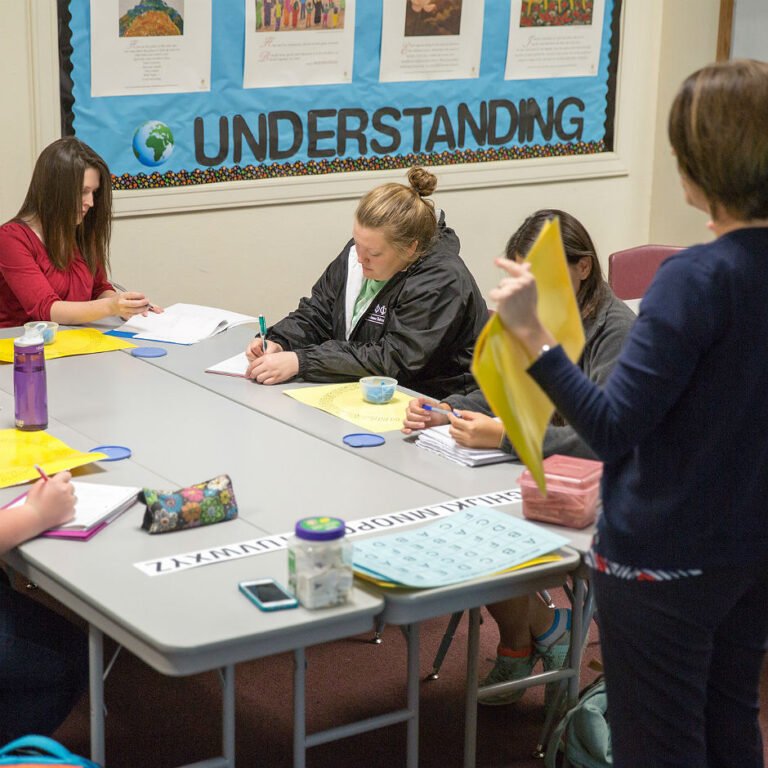 Dyslexic students practicing their writing skills at a table
