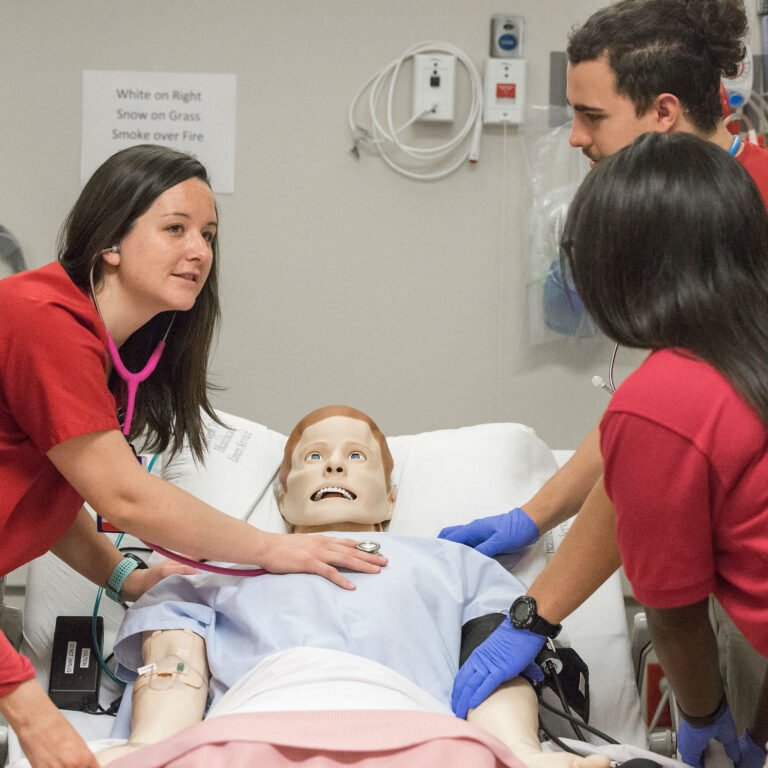 HSU nursing students examing dummy with a stethoscope