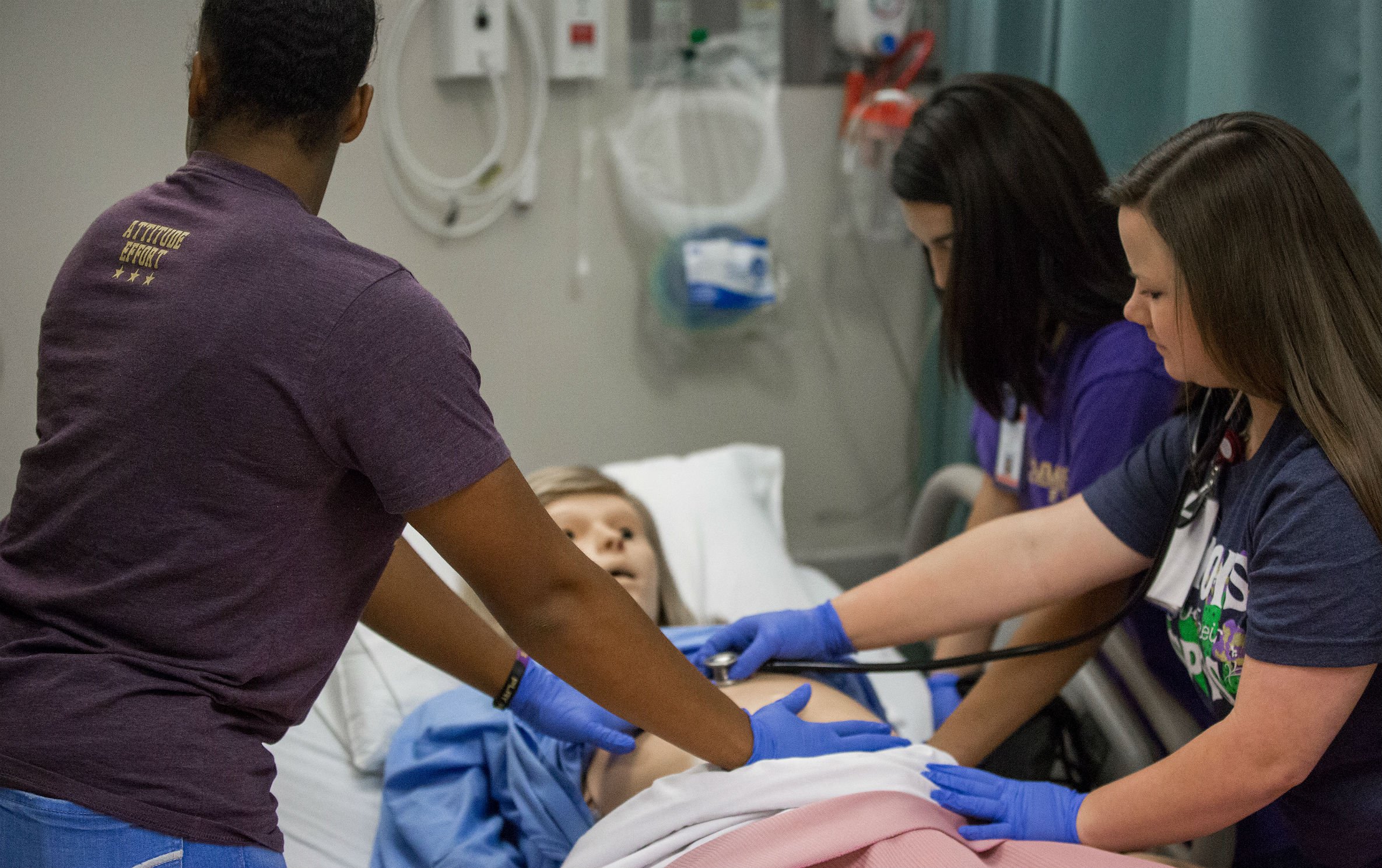 HSU nursing students examine a dummy in clinical studies