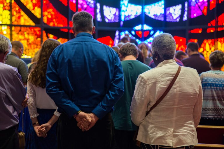 group of HSU students bowing thier heads and praying together