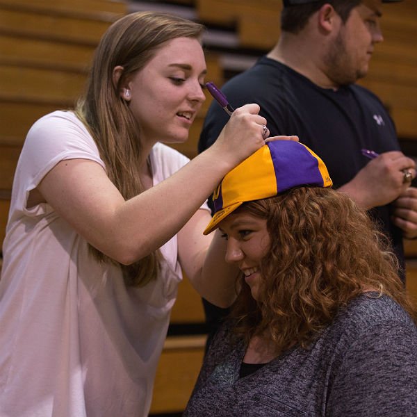 student signing another student's HSU hat