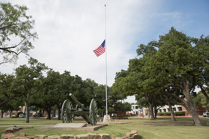 American Flag on a pole next to a cannon on campus