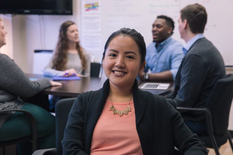 Graduate student sitting in class smiling