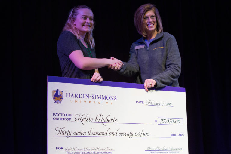 Photo of student , Kelsie Roberts receiving a award check of one full year scholarship.
