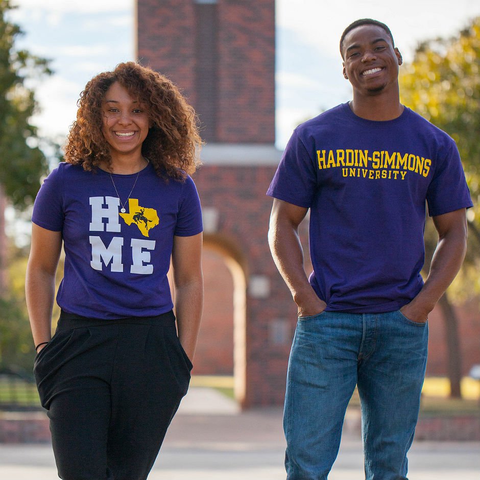 Two HSU students in purple HSU T-shirts.