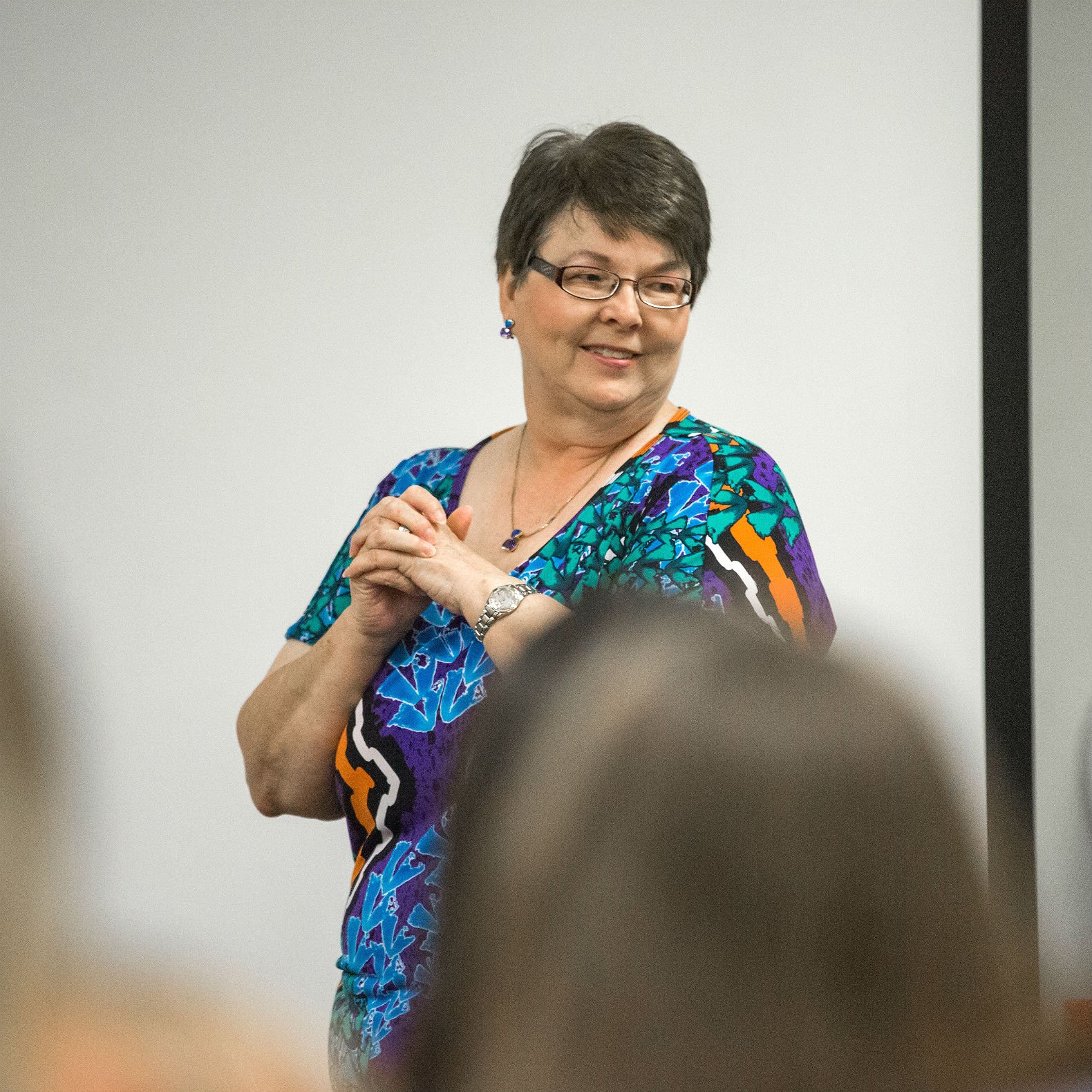 HSU Faculty member stands in focus at front of classroom.