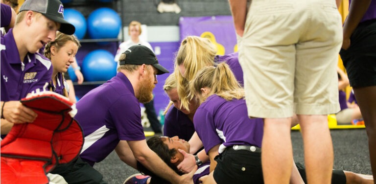 Athletic training students conduct an exercise with a student subject.