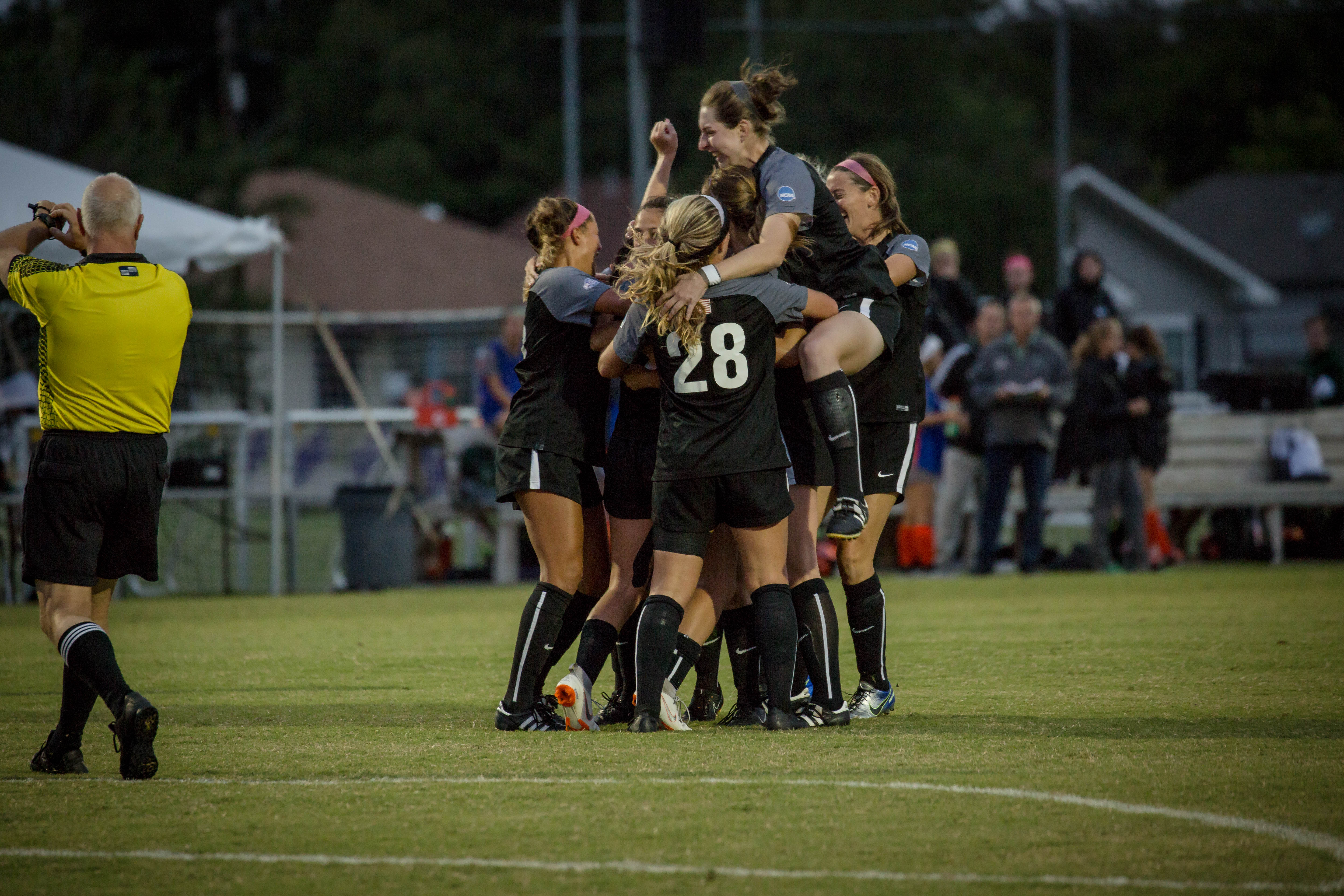 UT Dallas soccer players jumping in a hurdle