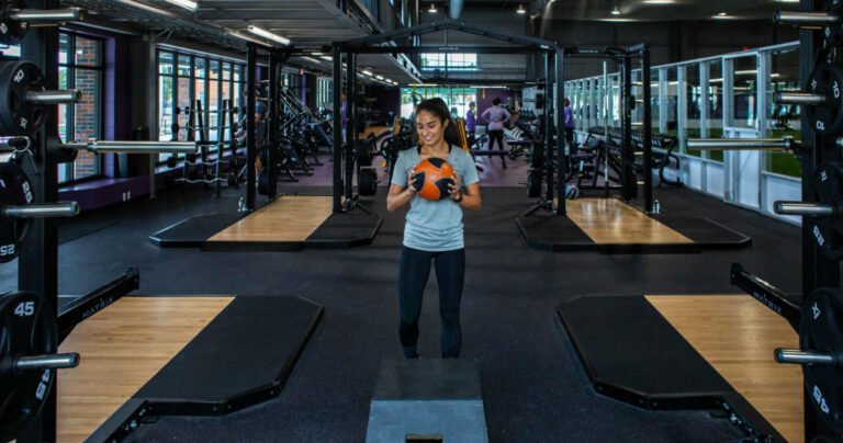 A young women exercises with a ball.