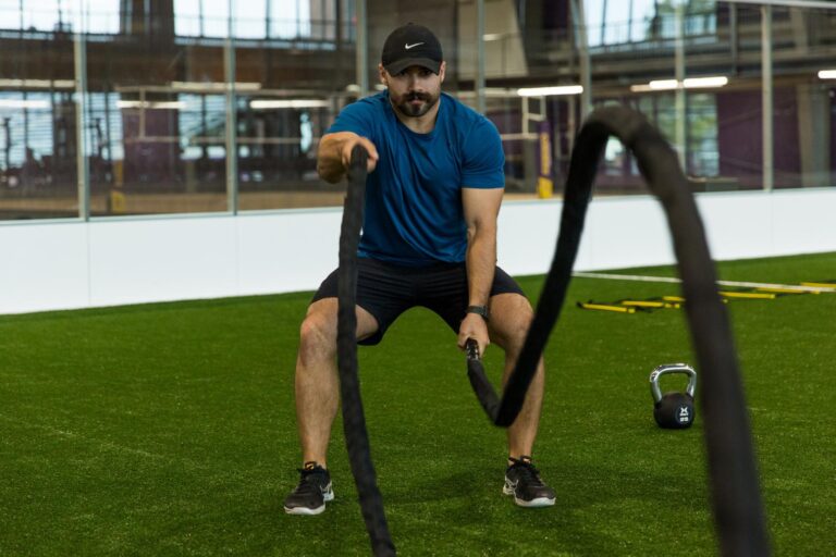 A man exercises with ropes.