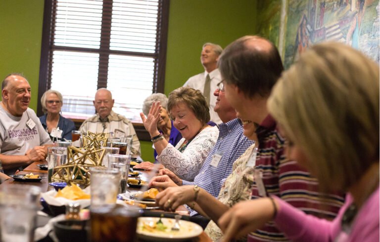 Alumni around a table at an alumni dinner